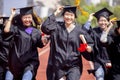 Happy graduation students  holding diploma and running on the stadium at school Royalty Free Stock Photo