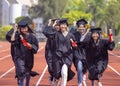Happy graduation students  holding diploma and running on the stadium at school Royalty Free Stock Photo