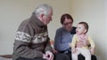Happy grand grandparents playing with a little toddler fussy at home 4k