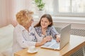 Adult granddaughter teaching her elderly grandmother to use laptop Royalty Free Stock Photo