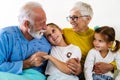 Happy grandchildren visiting grandfather at hospital ward. Support, family and healthcare concept. Royalty Free Stock Photo