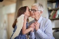 Happy granddaughter kissing grandmother in the cheek