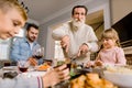 Happy grandfather cutting turkey for family on thanksgiving or christmas dinner Royalty Free Stock Photo