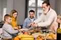 Happy grandfather cutting turkey for family on thanksgiving or christmas dinner Royalty Free Stock Photo