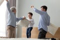 Happy grandfather, father and cute little son playing pillows battle