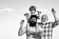 Happy grandfather father and grandson with toy paper airplane over blue sky and clouds background. Happy men loving Royalty Free Stock Photo