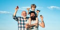 Happy grandfather father and grandson with toy paper airplane over blue sky and clouds background. Happy men loving Royalty Free Stock Photo