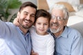 Happy grandfather, father and little son child taking selfie together