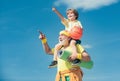 Happy grandfather giving grandson piggyback ride on his shoulders pointing and looking up. Different generations. Royalty Free Stock Photo