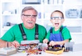 Happy grandfather and grandchild working in workshop Royalty Free Stock Photo