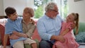 Happy grandfather and grandmother sitting on couch with grandchildren on laps Royalty Free Stock Photo