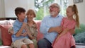 Happy grandfather and grandmother talking with grandchildren at home Royalty Free Stock Photo