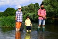 Happy grandfather and grandson are fishing on the river. Father, son and grandfather relaxing together. Men hobby Royalty Free Stock Photo