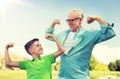 Happy grandfather and grandson showing muscles
