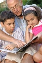 Happy grandfather and kids reading book