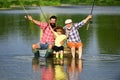 Happy Grandfather with son and grandson having fun in river. Men day. Father, son and grandfather on fishing trip. Royalty Free Stock Photo