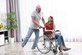 Happy grandfather and teenage girl in wheelchair