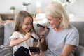 Happy grandma and granddaughter have fun doing make up