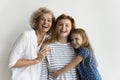 Happy grandma, mother and kid girl hugging at white background