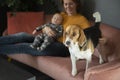 Happy grandmother,baby grandson and cute beagle dog on sofa