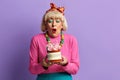 Happy Grandmother Blowing Candles. Fashionable Senior Lady Celebrates Birthday