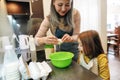 Happy grandmother cracking chicken eggs into big bowl