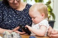 Happy grandmother and cute granddaughter using smartphone, teaching Royalty Free Stock Photo