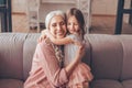 Happy grandmother and granddaughter embracing together at home Royalty Free Stock Photo