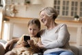 Happy grandmother and granddaughter use smartphone gadget Royalty Free Stock Photo