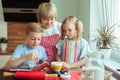 Happy grandmother with her grandchildren having fun during baking muffins and cookies Royalty Free Stock Photo