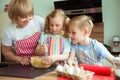 Happy grandmother with her grandchildren having fun during baking muffins and cookies Royalty Free Stock Photo