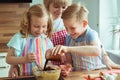 Happy grandmother with her grandchildren having fun during baking muffins and cookies Royalty Free Stock Photo