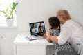 Happy grandmother and her granddaughter having video chat via laptop together at home Royalty Free Stock Photo