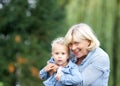 Happy grandmother holding baby girl outdoors Royalty Free Stock Photo