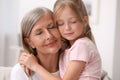 Happy grandmother hugging her granddaughter at home Royalty Free Stock Photo