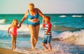 Happy grandmother with kids- little boy and girl- play at beach Royalty Free Stock Photo