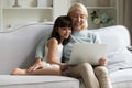 Happy grandmother and little granddaughter using laptop together at home Royalty Free Stock Photo