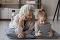 Happy grandmother and little granddaughter using tablet together Royalty Free Stock Photo
