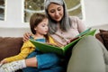 Happy grandmother reading book with granddaughter at home Royalty Free Stock Photo