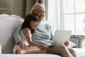 Happy grandmother and small granddaughter using laptop together Royalty Free Stock Photo