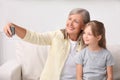 Happy grandmother taking selfie with her granddaughter at home Royalty Free Stock Photo