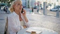 Happy grandmother talking cell phone at street cafe closeup. Old lady laughing Royalty Free Stock Photo