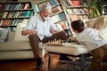 Happy grandpa and grandson playing chess together