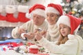 Happy grandparents with grandchild preparing for Christmas together Royalty Free Stock Photo