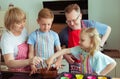 Happy grandparents have fun with their grandchildren preparing c