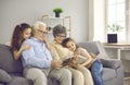 Happy grandparents with twin grandchildren browse family photo album and share happy memories. Royalty Free Stock Photo