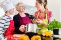 Granny, mum and son talking while cooking in kitchen Royalty Free Stock Photo