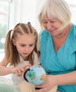 Happy granny showing globe to granddaughter