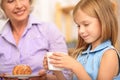 Happy granny treating granddaughter with breakfast Royalty Free Stock Photo