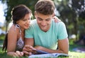 Happy, grass and couple with books for reading, learning and studying together outdoors at college. University Royalty Free Stock Photo